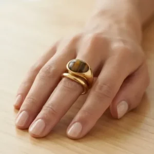 Bague bombée dorée avec cabochon œil de tigre portée à la main