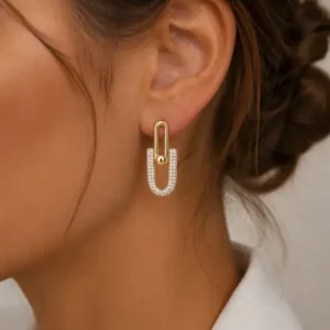 Boucles d'oreilles maillons étrier dorées et strass portées à l'oreille