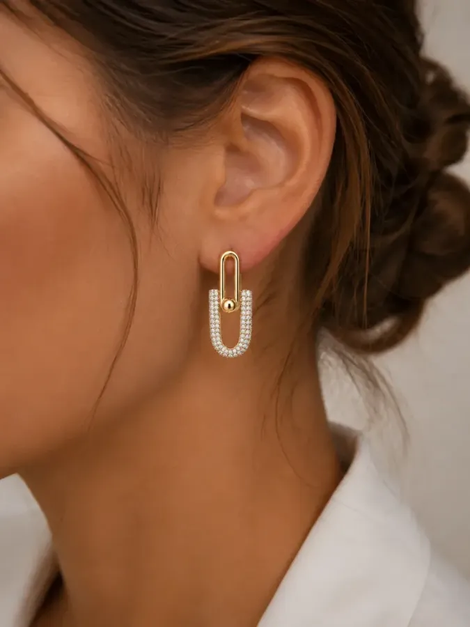 Boucles d'oreilles maillons étrier dorées et strass portées à l'oreille