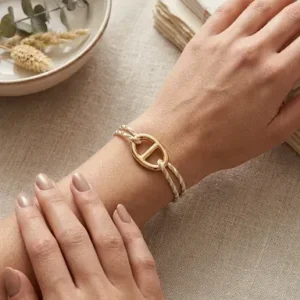 Bracelet cordon blanc et doré ajustable avec motif marin porté au poignet