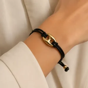 Bracelet cordon noir ajustable et maillon doré porté au poignet