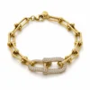 Bracelet chaîne maillons étrier U-link avec boucle centrale pavée de strass en acier inoxydable doré