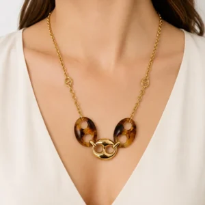 Collier doré avec pendentif maillon marin et résine écaille de tortue porté sur décolleté