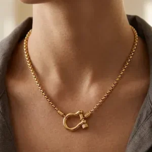 Collier doré à chaîne carrée et fermoir manille marin porté au cou