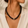 Collier ras de cou perles noires brillantes avec perle centrale ouvragée argentée et dorée